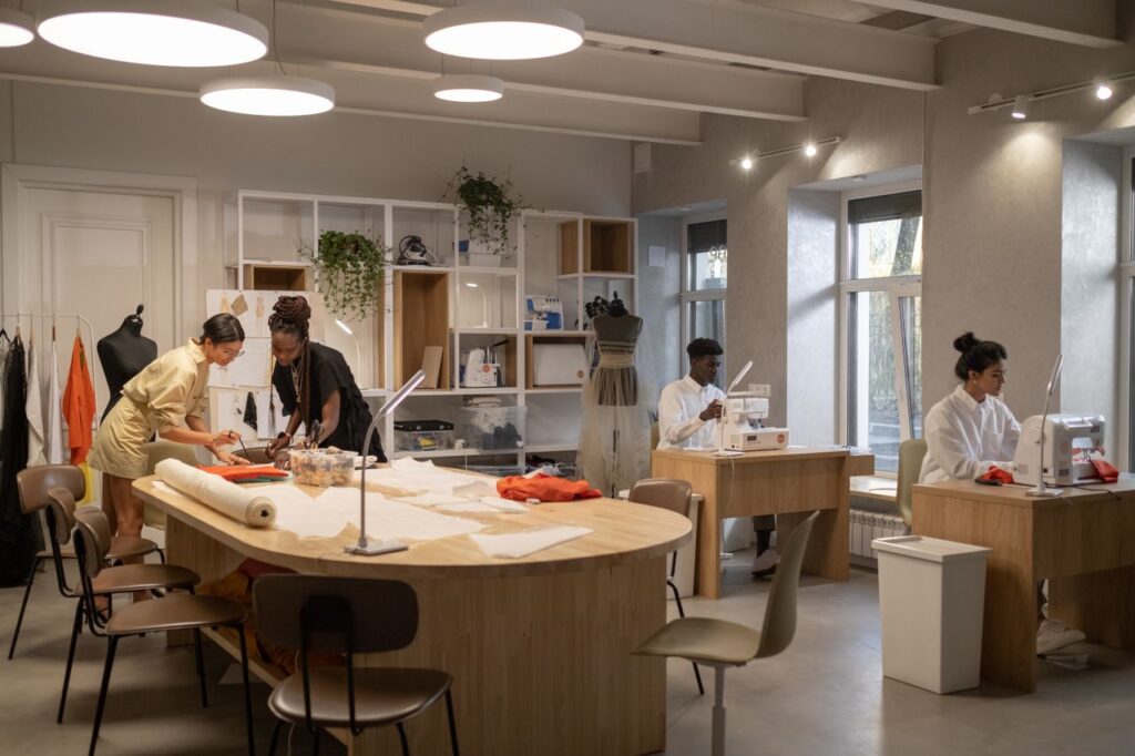 Fashion designers working together in a modern atelier with sewing machines and patterns.